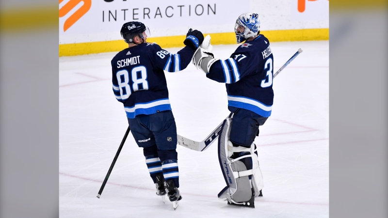 Winnipeg Jets goaltender Connor Hellebuyck (37) celebrates the win over the Arizona Coyotes with Nate Schmidt (88) during NHL action in Winnipeg on Tuesday March 21, 2023. THE CANADIAN PRESS/Fred Greenslade