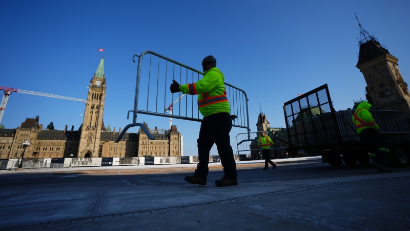 Work crews set up security fencing on Parliament Hill in Ottawa on Wednesday, March 22, 2023, in preparation for U.S. President Joe Biden’s visit. (Sean Kilpatrick/THE CANADIAN PRESS)