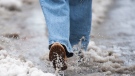 A person walks through water and slush in Montreal, Friday, Dec. 23, 2022. THE CANADIAN PRESS/Graham Hughes