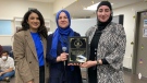 Kohawar Khan from Islamic Relief Canada presents a plaque to Hanan Haydar and Nancy Ferris from Calgary Islamic School for the students' efforts raising money for earthquake victims in Turkiye ans Syria.