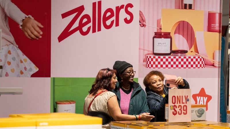 Shoppers take a selfie with a Zellers sign in a newly opened store in Scarborough Town Centre Mall on Thursday March 23, 2023. THE CANADIAN PRESS/Chris Young