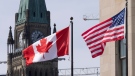 Canadian and United States flags are seen flying near Parliament Hill, Wednesday, March 22, 2023 in Ottawa. THE CANADIAN PRESS/Adrian Wyld