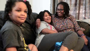 Deleah Payne, 12, centre, spends time with her mother, Delisa, right, and 6-year-old sister, Delynn, left, as they watch movie clips on their living room television in Evansville, Ind., Tuesday evening, Aug. 27, 2019. Deleah and Delynn were both diagnosed with autism. (Sam Owens/Evansville Courier & Press via AP, File) 
