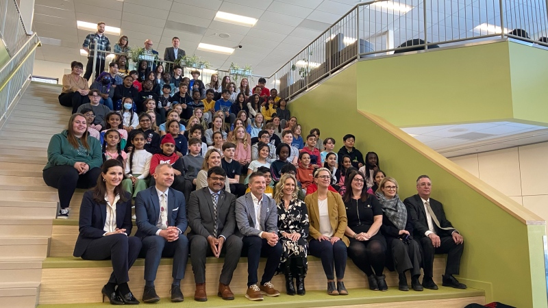 Stakeholders, as well as municipal and provincial leaders, pose with students from Harbour Landing School for a photo at a media event announcing the location of the new Harbour Landing West School. (Donovan Maess / CTV News) 