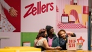 Shoppers take a selfie with a Zellers sign in a newly opened Zellers store in Scarborough Town Centre Mall, in Scarborough, Ont., on Thursday March 23, 2023. THE CANADIAN PRESS/Chris Young 
