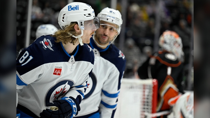 Winnipeg Jets left wing Kyle Connor, left, reacts after scoring against Anaheim Ducks goaltender Lukas Dostal, right, with right wing Nino Niederreiter, center, looking on during the second period of an NHL hockey game in Anaheim, Calif., Thursday, March 23, 2023. (AP Photo/Alex Gallardo)