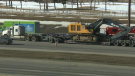 A truck driver faces charges after the excavator they were hauling collided with the underside of the 32nd Avenue N.E. overpass above Deerfoot Trail on March 23.