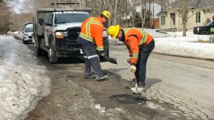 City of Waterloo crew members Mike Aarens and Wayne Wideman fill potholes on Lee Avenue. (Dan Lauckner/CTV Kitchener) 