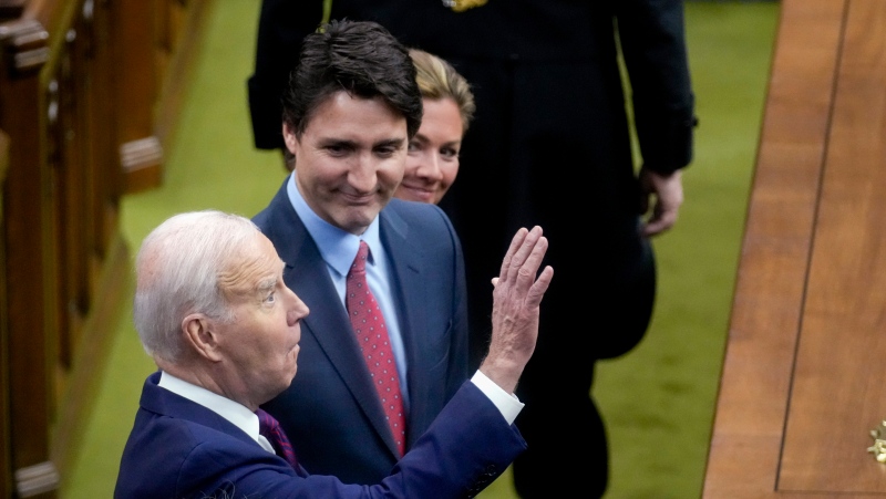 U.S. President Joe Biden, accompanied by first lady Jill Biden, Prime Minister Justin Trudeau and his wife Sophie Gregoire Trudeau, waves as he arrives to speak at the Canadian Parliament, Friday, March 24, 2023, in Ottawa. (AP Photo/Andrew Harnik, Pool)