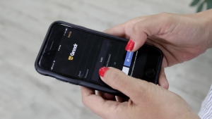 In this Wednesday, May 29, 2019, file photo, a woman looks at the Grindr app on her mobile phone in Beirut, Lebanon. (AP Photo/Hassan Ammar, File)
