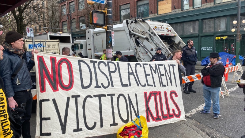 Protesters held a sign reading “no displacement” and “eviction kills” on Friday, March 24, 2023. Vancouver police and city staff are continuing efforts to dismantle what's known as the East Hastings encampment, as per a July order from the fire chief. (Twitter/ VANDU)