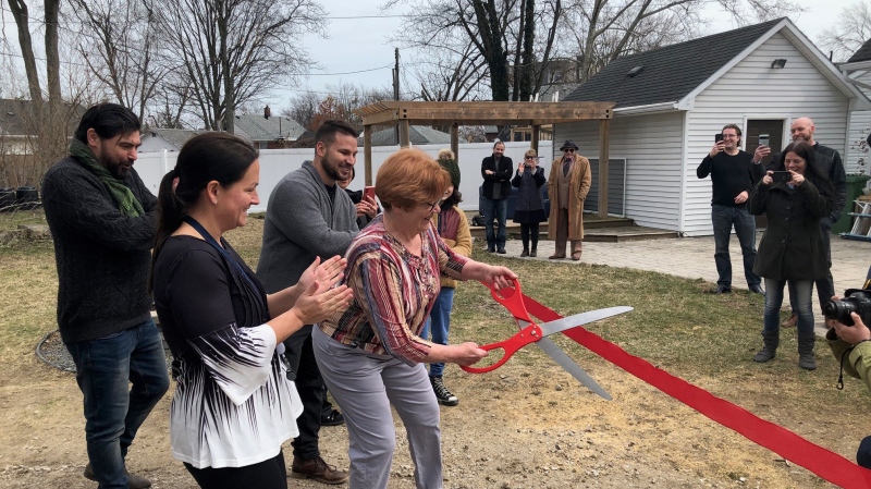 Resident Cherri Robbins cuts the ribbon to her new ‘tiny home’ in Essex, Ont. on Friday, Mar. 23, 2023. (Gary Archibald/CTV News Windsor)