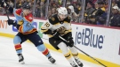 Boston Bruins left wing A.J. Greer (10) and Florida Panthers defenseman Brandon Montour (62) battle for the puck during the first period of an NHL hockey game, Saturday, Jan. 28, 2023, in Sunrise, Fla. THE CANADIAN PRESS/AP, Wilfredo Lee