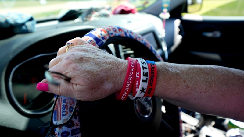 Angie Alexander, of Houston, parks her car while gathering with others near the Waco Regional Airport ahead of former U.S. president Donald Trump's first 2024 campaign rally, March 24, 2023, in Waco, Texas. (AP Photo/Julio Cortez)
