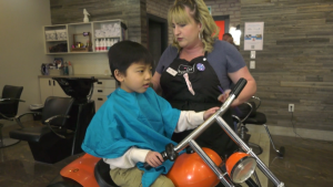 Fallon Grant, a stylist at Beaners Fun Cuts in St. Albert, cuts a child's hair on March 25, 2023. 