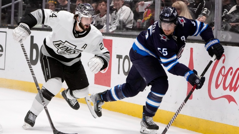 Winnipeg Jets center Mark Scheifele (55) passes next to Los Angeles Kings center Phillip Danault (24) during the first period of an NHL hockey game Saturday, March 25, 2023, in Los Angeles. (AP Photo/Marcio Jose Sanchez)