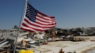 An American flag files on the slab of what was a hardware store in Rolling Fork, Miss., Saturday morning, March 25, 2023. Emergency officials in Mississippi say several people have been killed by tornadoes that tore through the state on Friday night, destroying buildings and knocking out power as severe weather produced hail the size of golf balls moved through several southern states. (AP Photo/Rogelio V. Solis)