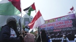 Protesters wave Palestinian flag during a protest in Jakarta, Indonesia, on March 20, 2023. Hundreds of conservative Muslims have marched to the streets in Indonesia's capital to protest against the Israeli team's participation in the FIFA World Cup Under-20 in Indonesia. (AP Photo/Achmad Ibrahim)