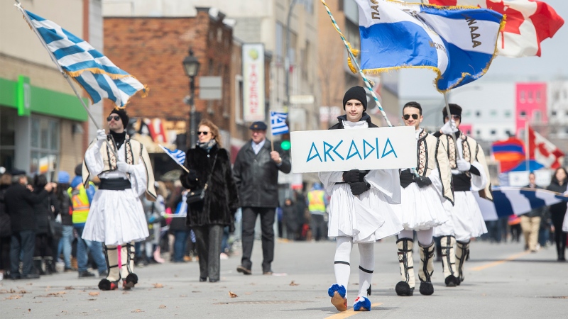 Participants hold flags during the Greek Independence Day parade in Montreal, Sunday, March 27, 2022. THE CANADIAN PRESS/Graham Hughes