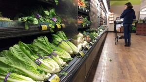 In this Nov. 20, 2018, file photo, romaine lettuce sits on the shelves as a shopper walks through the produce area of an Albertsons market in Simi Valley, Calif. (AP Photo/Mark J. Terrill, File)