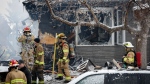 Firefighters attend the scene of a house explosion that injured several people, destroyed one home and damaged others in Calgary, Alta., Monday, March 27, 2023.THE CANADIAN PRESS/Jeff McIntosh