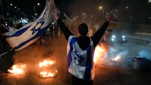Anti-government protestors burn tires near Beit Yanai, Israel, Monday, March 27, 2023. Tens of thousands Israelis protest against Prime Minister Benjamin Netanyahu's judicial overhaul plan.(AP Photo/Ariel Schalit) 