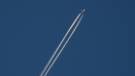 An airliner cuts through the skies over Montreal, Dec. 23, 2020. THE CANADIAN PRESS/Paul Chiasson