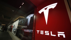 A sign bearing the Tesla company logo is displayed outside a Tesla store in Cherry Creek Mall in Denver, Colorado, Feb. 9, 2019. (AP Photo/David Zalubowski, File)