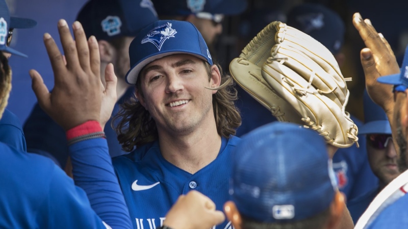 Toronto Blue Jays starting pitcher Kevin Gausman met by teammates in the dugout after throwing an inning of action against the Tampa Bay Rays in their spring training game in Dunedin, Florida on Friday, March 3, 2023. THE CANADIAN PRESS/Fred Thornhill
