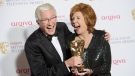 British presenters Paul O'Grady, left, and Cilla Black joke with her Special Award at the British Academy Television Awards at a central London venue, Sunday, May 18, 2014. (Photo by Jonathan Short/Invision/AP, File)