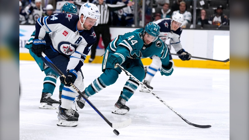 Winnipeg Jets defenseman Josh Morrissey (44) moves the puck up the ice past San Jose Sharks defenseman Marc-Edouard Vlasic (44) during the second period of an NHL hockey game Tuesday, March 28, 2023, in San Jose, Calif. (AP Photo/Tony Avelar)