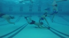 Athletes playing underwater football.