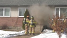 Smoke pours out of a home at 89 Avenue and 154 Street in Edmonton on March 29, 2023.