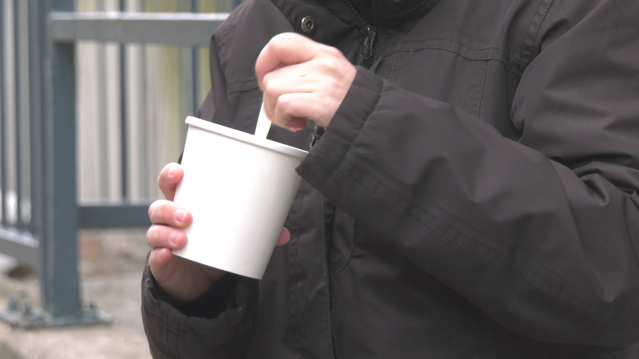 An individual eats food out of a cup in Barrie, Ont. (CTV News/Ian Duffy)