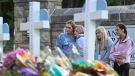 Students at a nearby school pay respects at a memorial for victims at an entry to Covenant School, Tuesday, March 28, 2023, in Nashville, Tenn. (AP Photo/John Amis)