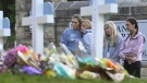 Students at a nearby school pay respects at a memorial for the people who were killed, at an entry to Covenant School, Tuesday, March 28, 2023, in Nashville, Tenn. (AP Photo/John Amis)