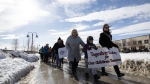 People march from the RCMP headquarters to the Kwanlin Dun Cultural Centre to raise awareness of the Yukon overdose crisis in Whitehorse on Wednesday, March 22, 2023. (THE CANADIAN PRESS/Crystal Schick)