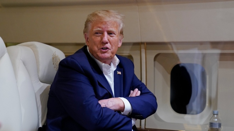 Former President Donald Trump speaks with reporters while in flight on his plane after a campaign rally at Waco Regional Airport, in Waco, Texas, March 25, 2023, while en route to West Palm Beach, Fla. (AP Photo/Evan Vucci)