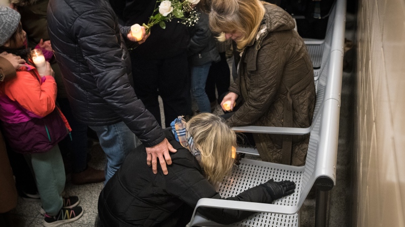 Andrea Magalhaes is overcome with emotion after seeing the bench at Keele Station, where where her 16-year-old son, Gabriel Magalhaes, was killed in a random attack, during a candlelight walk in Toronto on Thursday, March 30, 2023. THE CANADIAN PRESS/Tijana Martin