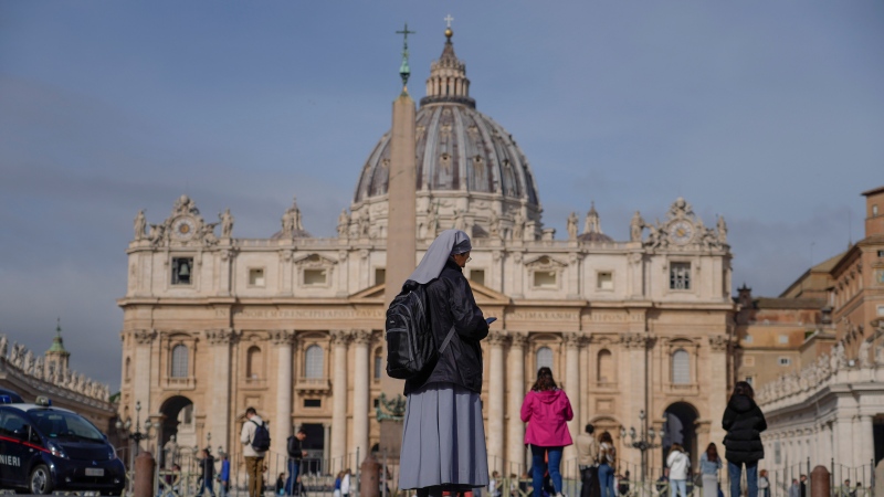 A nun checks her phone in front of St. Peter's Square at the Vatican, Thursday, March 30, 2023. (AP Photo/Gregorio Borgia) 