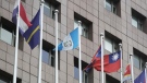 The Guatemalan national flag, center left, flies next to a pole left vacant by the Honduran national flag, outside the Diplomatic Quarter building in Taipei, Taiwan, Sunday, March 26, 2023. (AP Photo/Chiang Ying-ying)