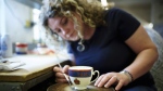 Gilder Nicola Gildchrist works on a teacup at the Duchess China 1888 factory, in Stoke-on-Trent, England, Thursday, March 30, 2023. (AP Photo/Jon Super)