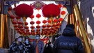 Shoppers visit a popular retail street in Beijing on Saturday, Feb. 26, 2022. (AP Photo/Ng Han Guan, File)