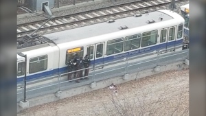 Edmonton police stand outside a LRT car at the Health Sciences/Jubilee LRT station near the University of Alberta Hospital on March 31, 2023. 