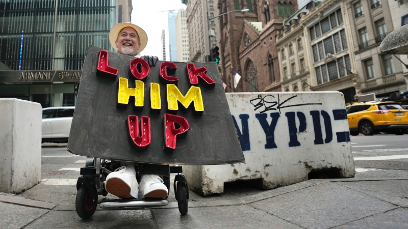 Richard Fisher protests former U.S. President Donald Trump outside Trump Tower on Friday, March 31, 2023, in New York. (AP Photo/Bryan Woolston)