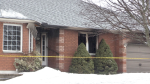 Yellow caution tape surrounds a house following a fire in Penetanguishene, Ont., on Fri., March 31, 2023. (CTV News/Steve Mansbridge)