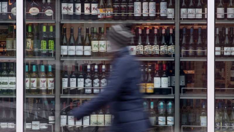 A person walks past shelves of bottles of alcohol on display at an LCBO in Ottawa, Thursday March 19, 2020. THE CANADIAN PRESS/Adrian Wyld
