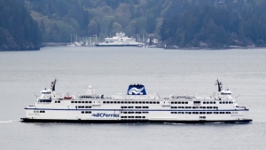 A BC Ferries vessel passes Bowen Island while traveling on Howe Sound from Horseshoe Bay to Langdale, B.C., on Friday, April 23, 2021. (Darryl Dyck/THE CANADIAN PRESS)