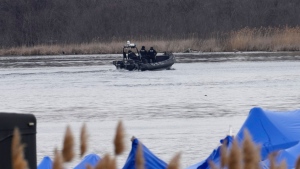 A police boat searches the area in Akwesasne, Que., Friday, March 31, 2023. Authorities in the Mohawk Territory of Akwesasne say one child is missing after the bodies of six migrants of Indian and Romanian descent were pulled from the river Thursday. THE CANADIAN PRESS/Ryan Remiorz
