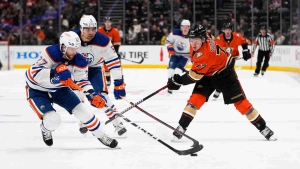 Edmonton Oilers' Brett Kulak (27) takes the puck away from Anaheim Ducks' Frank Vatrano (77) during the third period of an NHL hockey game Wednesday, Jan. 11, 2023, in Anaheim, Calif. The Oilers won 6-2. (AP Photo/Jae C. Hong)